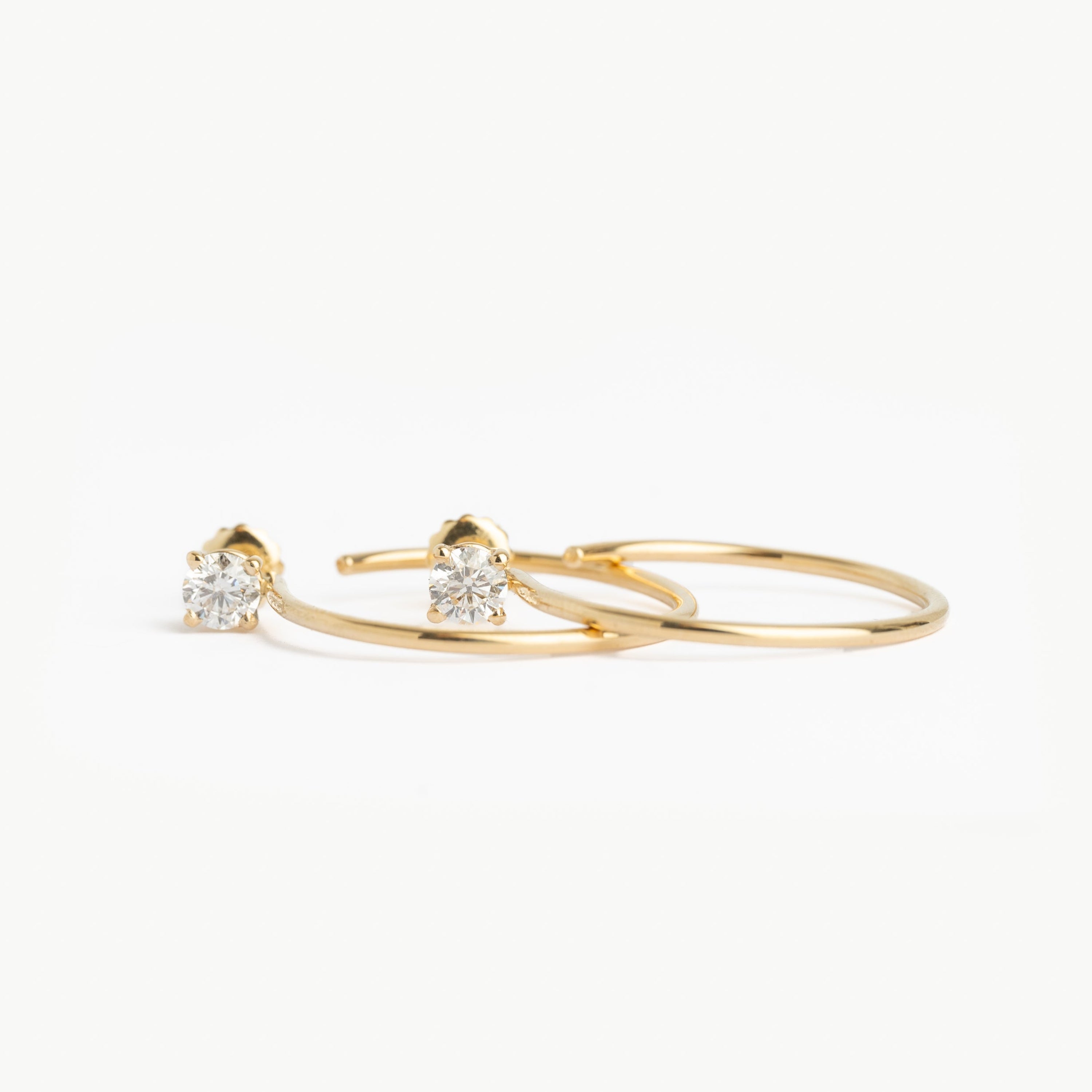 Gold hoop earrings with clear gemstones on a white background