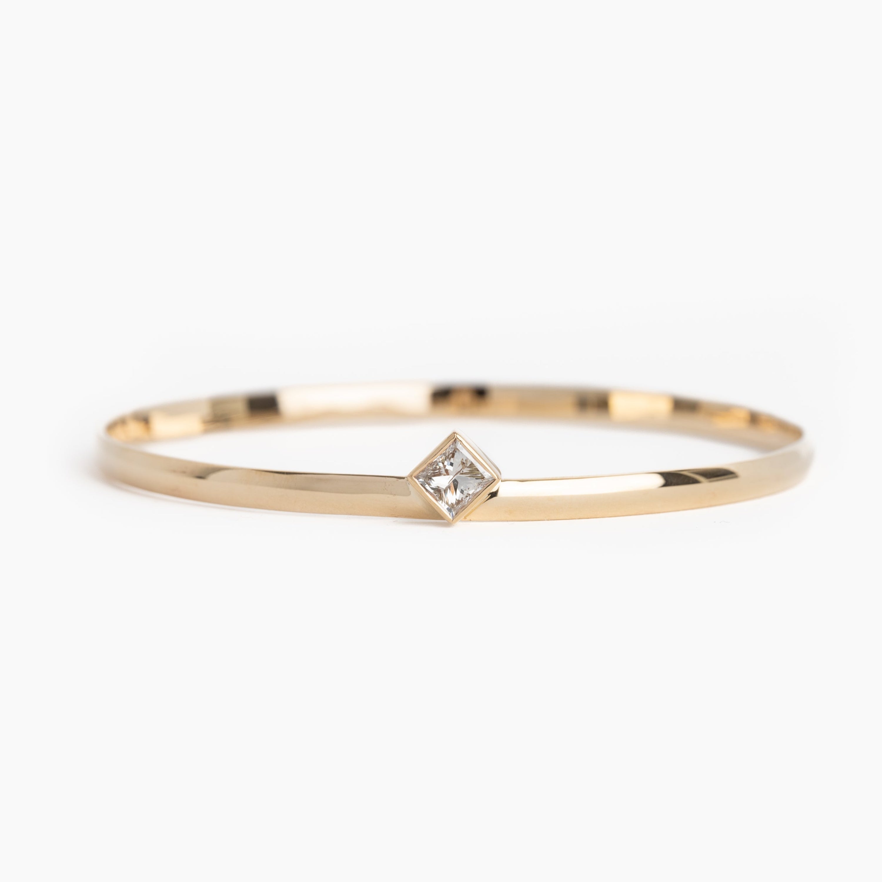 Gold ring with a small diamond on a white background