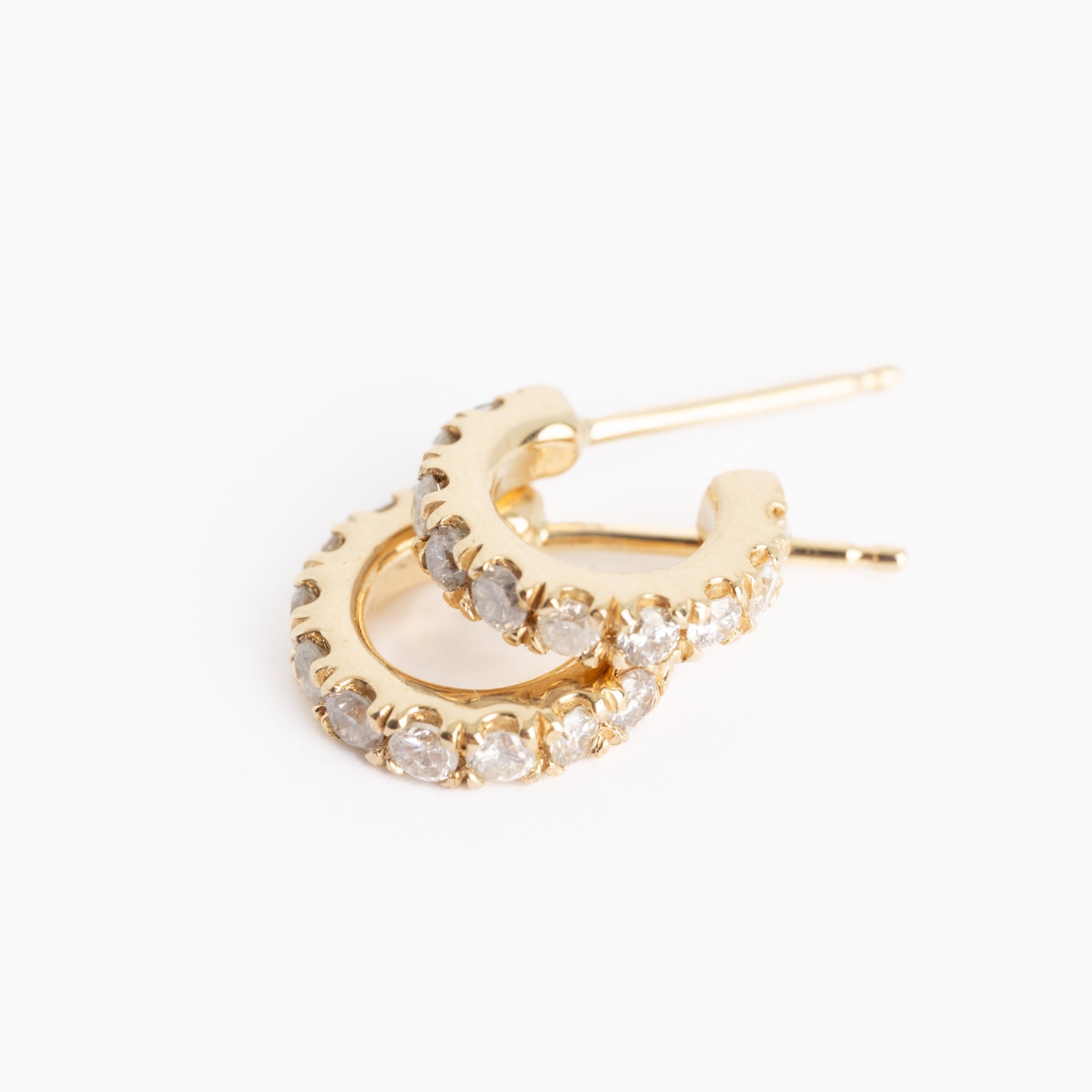 Gold hoop earring with diamonds on a white background