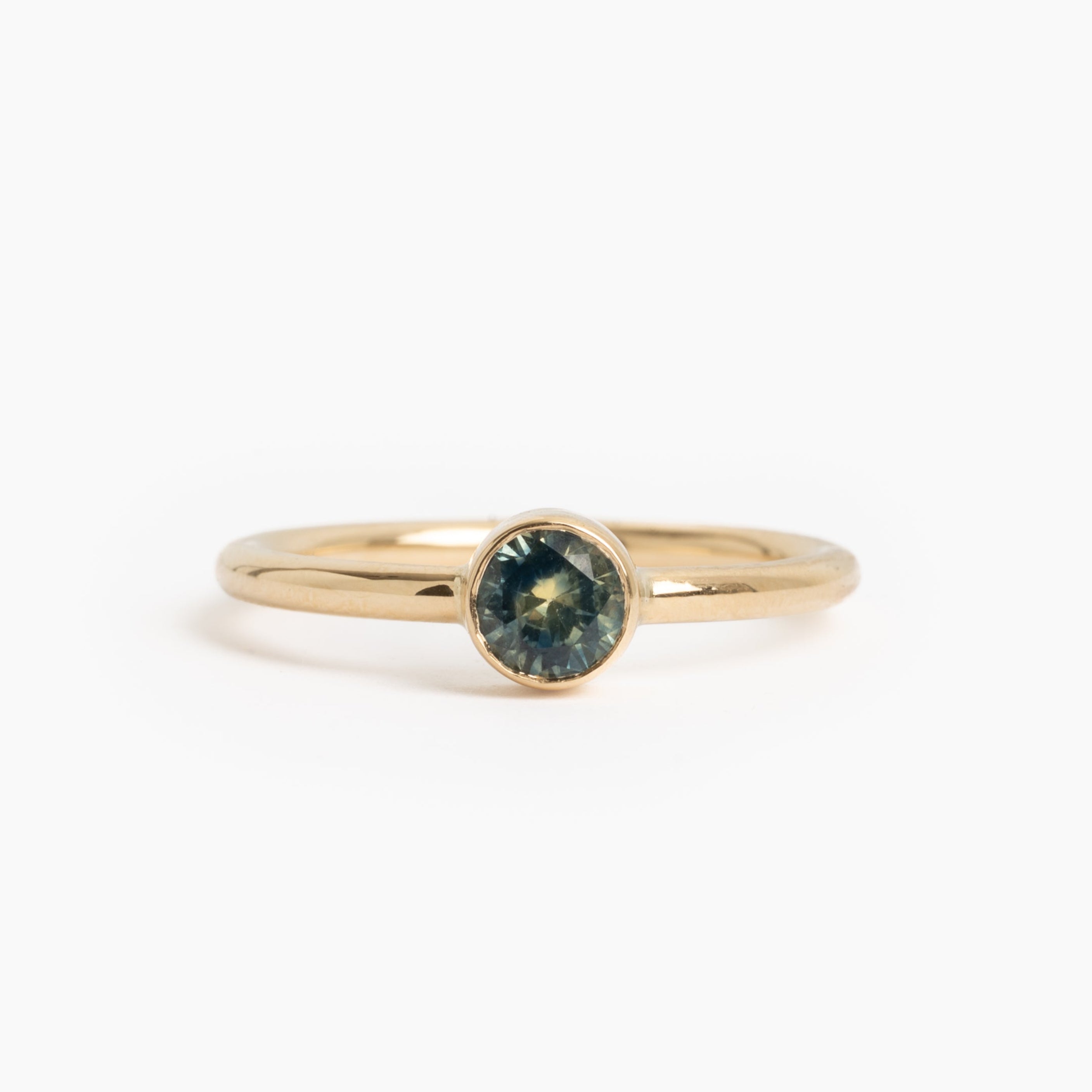 Gold ring with a green gemstone on a white background