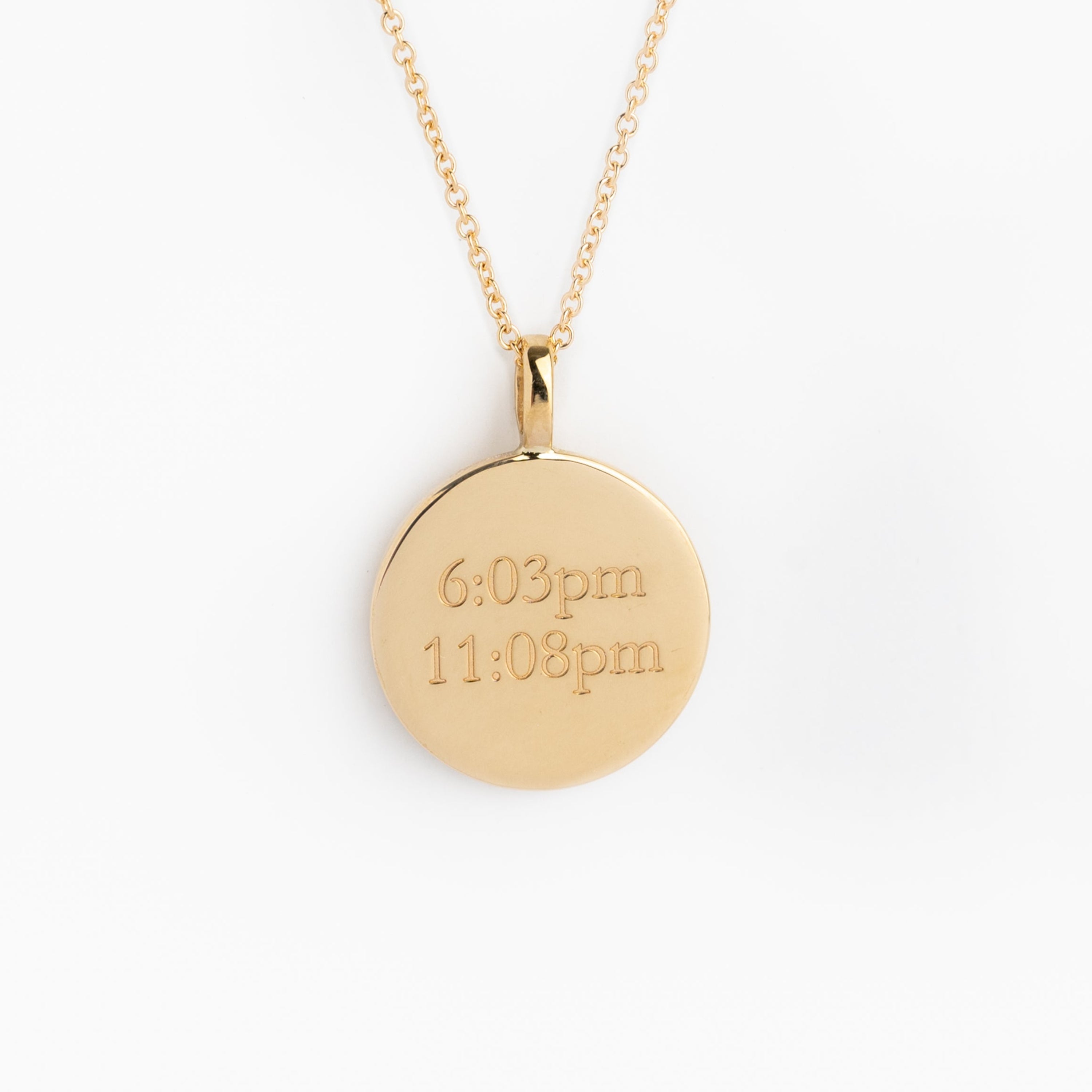 Gold necklace with a round pendant on a white background