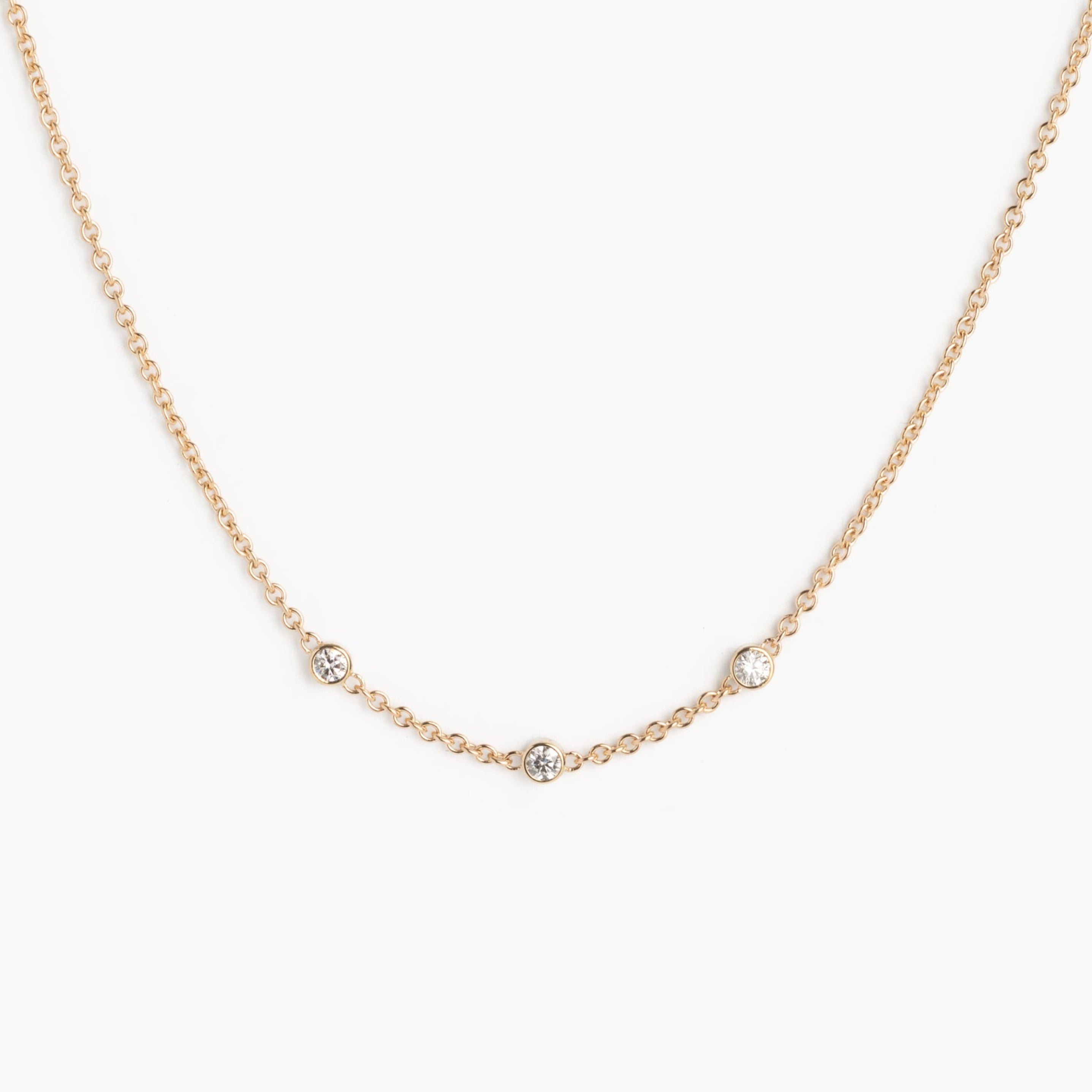 Gold necklace with small diamonds on a white background