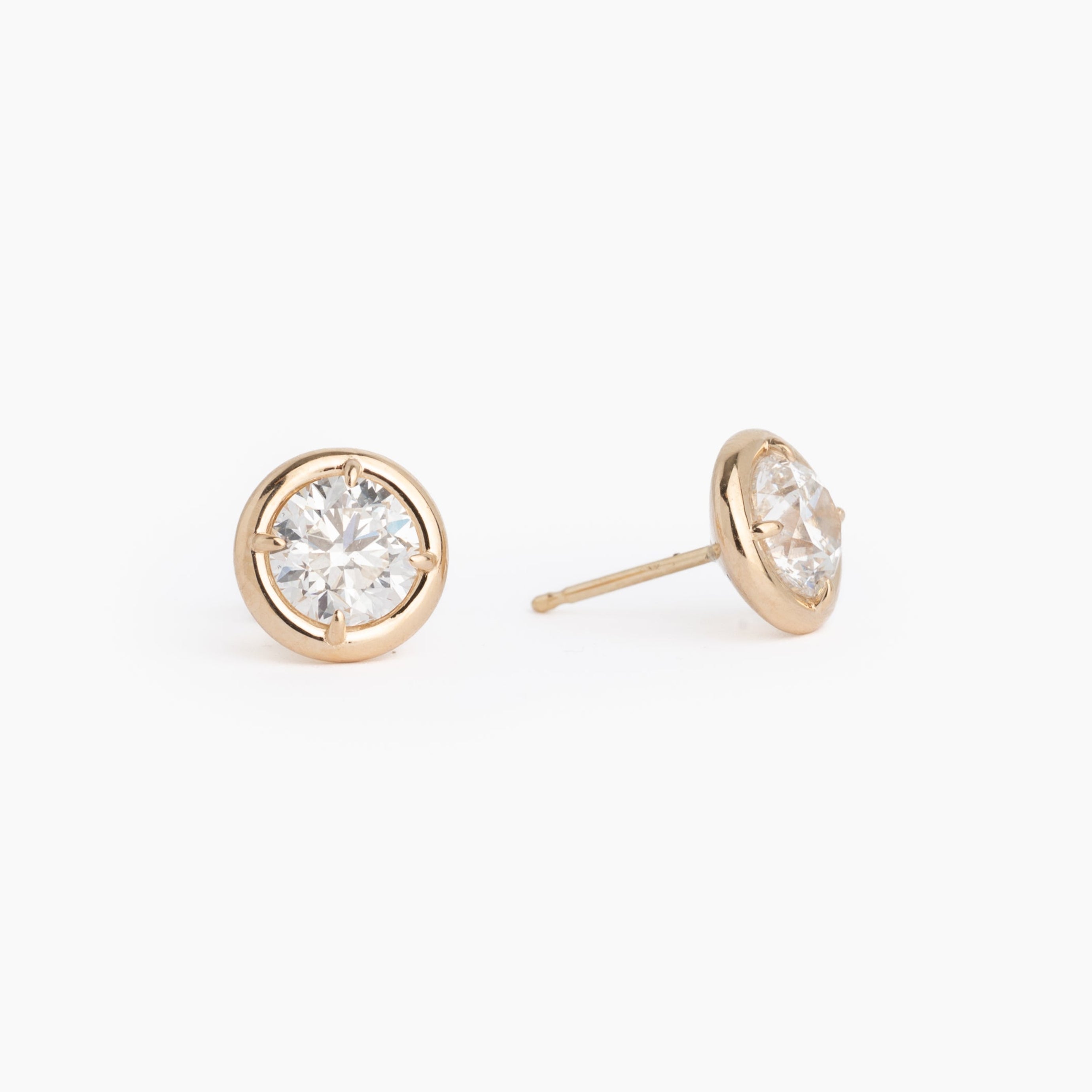 Gold stud diamond earrings on a white background